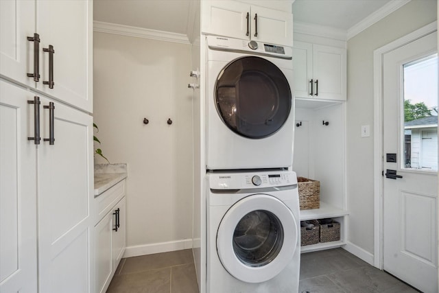 7810 Pagewood Ln, Houston, TX 77063 - washroom with stacked washer and clothes dryer, cabinet space, crown molding, tile patterned flooring, and baseboards
