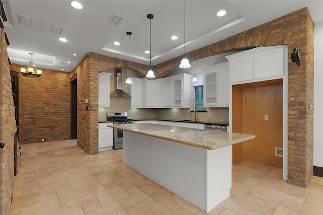 406 Fenn St Unit B, Houston, TX 77018 - kitchen with appliances with stainless steel finishes, wall chimney range hood, a sink, a tray ceiling, and stone tile floors