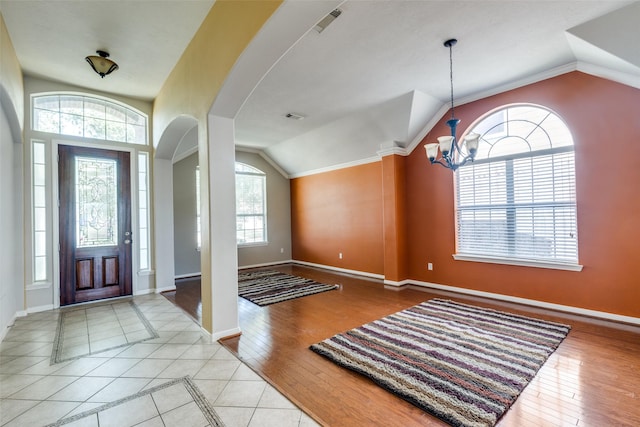 2803 Youpon Glen Way, Fresno, TX 77545 - foyer entrance featuring vaulted ceiling, a chandelier, baseboards, arched walkways, and wood finished floors