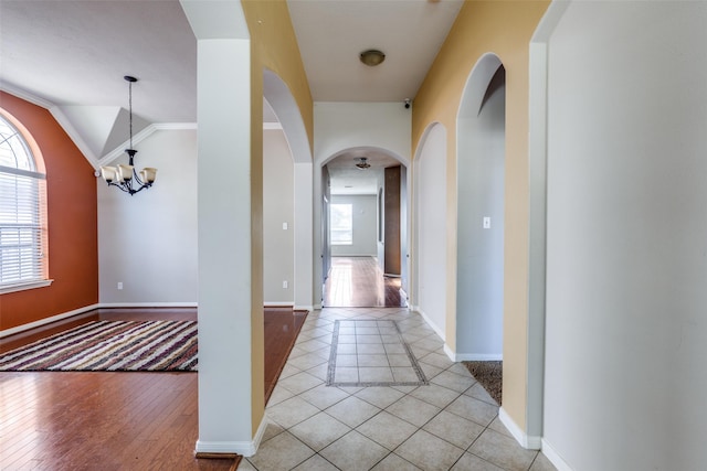 2803 Youpon Glen Way, Fresno, TX 77545 - corridor with arched walkways, a chandelier, light tile patterned floors, baseboards, and lofted ceiling