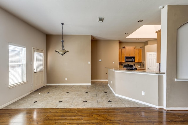 2803 Youpon Glen Way, Fresno, TX 77545 - kitchen with black microwave, stove, baseboards, light countertops, and light tile patterned floors