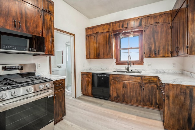 3309 Avenue N, Galveston, TX 77550 - kitchen with black appliances, light wood-style flooring, and light countertops