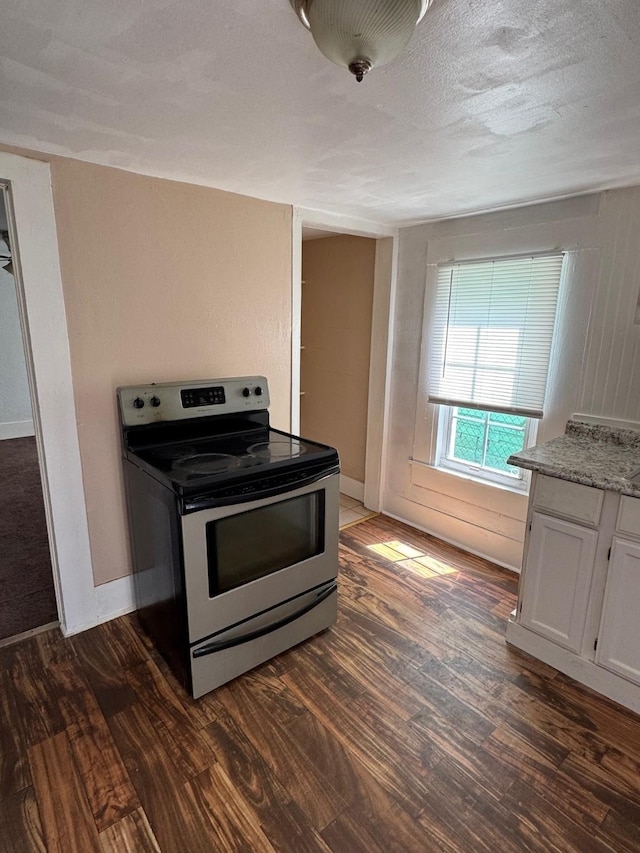 3309 Avenue N, Galveston, TX 77550 - kitchen with electric range, white cabinetry, dark wood-type flooring, and light stone countertops