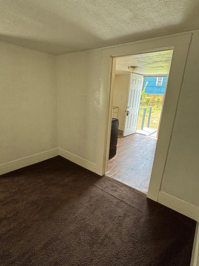3309 Avenue N, Galveston, TX 77550 - spare room featuring dark carpet, a textured ceiling, and a textured wall