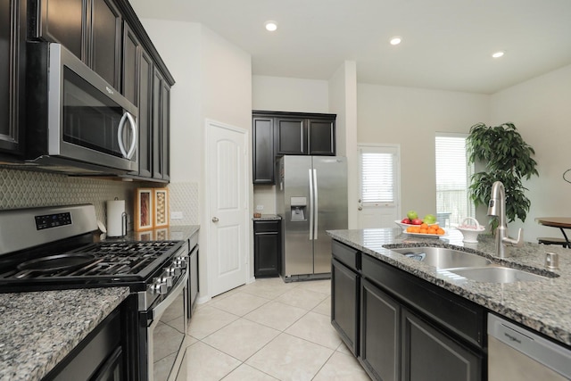 24710 Royal Pike Dr, Katy, TX 77493 - kitchen with appliances with stainless steel finishes, a sink, light stone counters, light tile patterned floors, and tasteful backsplash