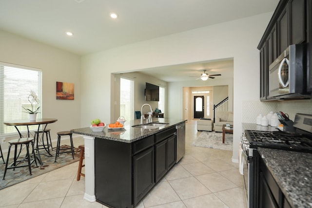 24710 Royal Pike Dr, Katy, TX 77493 - kitchen featuring appliances with stainless steel finishes, a sink, light tile patterned floors, dark stone countertops, and recessed lighting