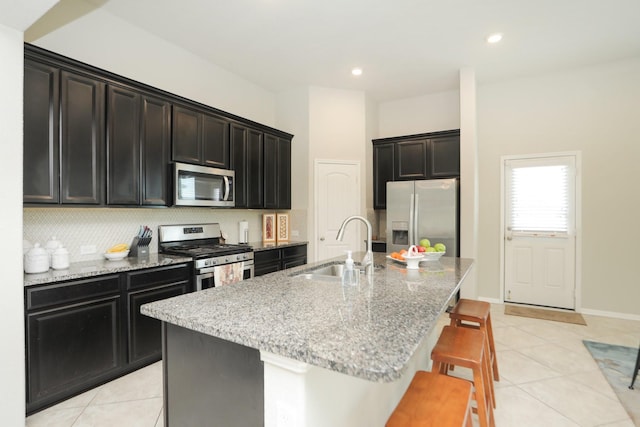 24710 Royal Pike Dr, Katy, TX 77493 - kitchen featuring appliances with stainless steel finishes, a sink, light tile patterned floors, light stone countertops, and recessed lighting