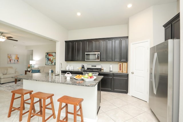 24710 Royal Pike Dr, Katy, TX 77493 - kitchen with appliances with stainless steel finishes, a sink, open floor plan, decorative backsplash, and light tile patterned flooring