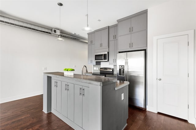 1011 Studemont St Unit 304, Houston, TX 77007 - kitchen with stainless steel appliances, gray cabinets, dark countertops, dark wood finished floors, and a kitchen island with sink