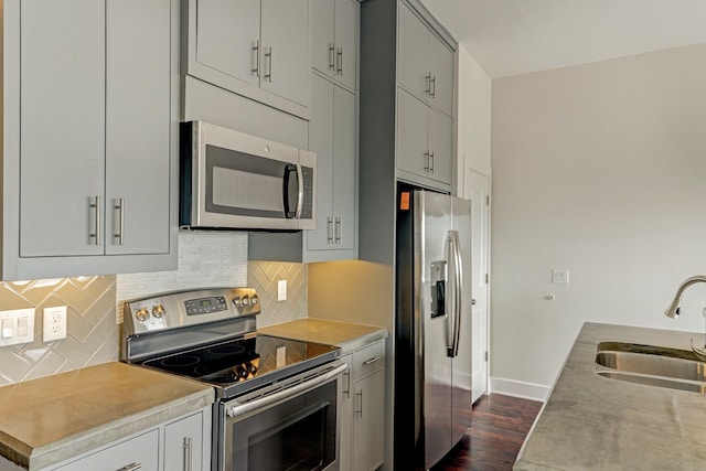 1011 Studemont St Unit 304, Houston, TX 77007 - kitchen with appliances with stainless steel finishes, a sink, dark wood-style floors, baseboards, and light countertops