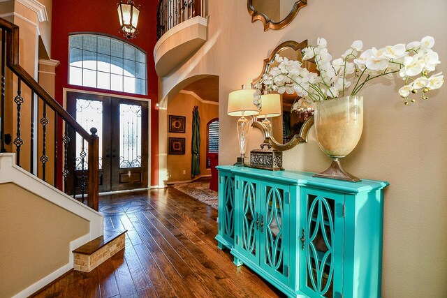 902 Delford Way, Sugar Land, TX 77479 - foyer entrance featuring arched walkways, wood-type flooring, a towering ceiling, stairs, and baseboards