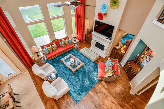 902 Delford Way, Sugar Land, TX 77479 - living area featuring a towering ceiling, a fireplace, a ceiling fan, and wood finished floors