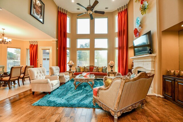 902 Delford Way, Sugar Land, TX 77479 - living room with ceiling fan, ornamental molding, a chandelier, hardwood / wood-style floors, and a fireplace