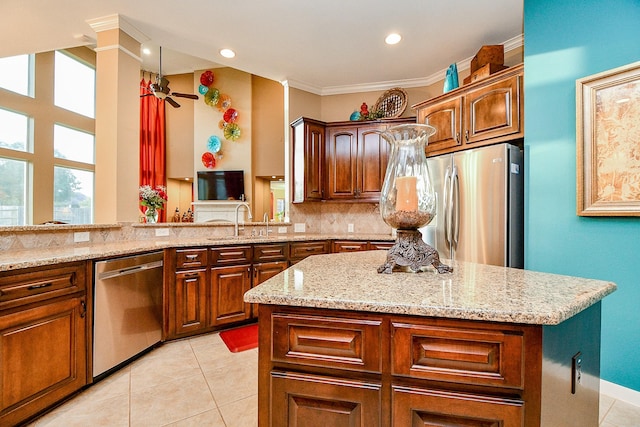 902 Delford Way, Sugar Land, TX 77479 - kitchen featuring appliances with stainless steel finishes, a sink, light stone countertops, light tile patterned floors, and a kitchen island