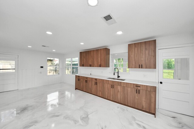 5419 N Crooked Creek Dr, Houston, TX 77017 - kitchen featuring a sink, brown cabinetry, light countertops, plenty of natural light, and recessed lighting