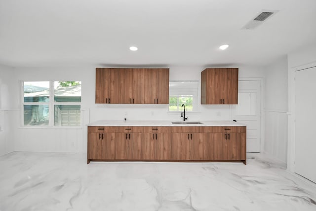 5419 N Crooked Creek Dr, Houston, TX 77017 - kitchen with a sink, brown cabinets, light countertops, recessed lighting, and light marble finish flooring