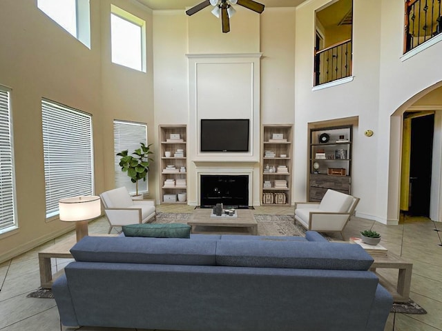3003 Mystic Frst, Missouri City, TX 77459 - living room with a towering ceiling, arched walkways, ceiling fan, built in shelves, and light tile patterned flooring