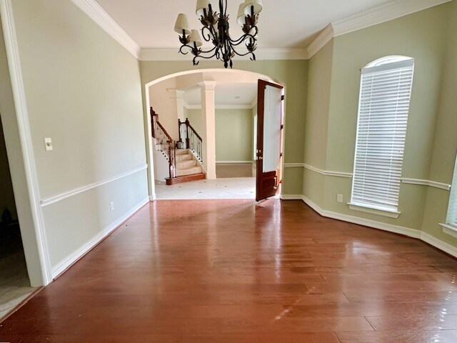 3003 Mystic Frst, Missouri City, TX 77459 - unfurnished dining area with ornate columns, arched walkways, wood finished floors, crown molding, and a chandelier