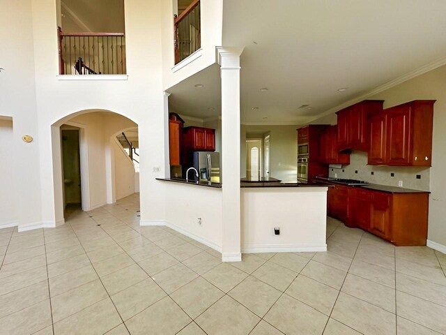 3003 Mystic Frst, Missouri City, TX 77459 - kitchen featuring dark brown cabinets, appliances with stainless steel finishes, dark countertops, light tile patterned floors, and ornamental molding