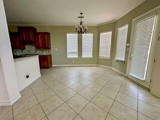 3003 Mystic Frst, Missouri City, TX 77459 - kitchen featuring reddish brown cabinets, light tile patterned flooring, backsplash, ornamental molding, and a chandelier