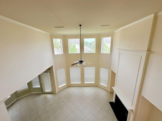 3003 Mystic Frst, Missouri City, TX 77459 - unfurnished living room with ornamental molding, a ceiling fan, healthy amount of natural light, and light tile patterned floors