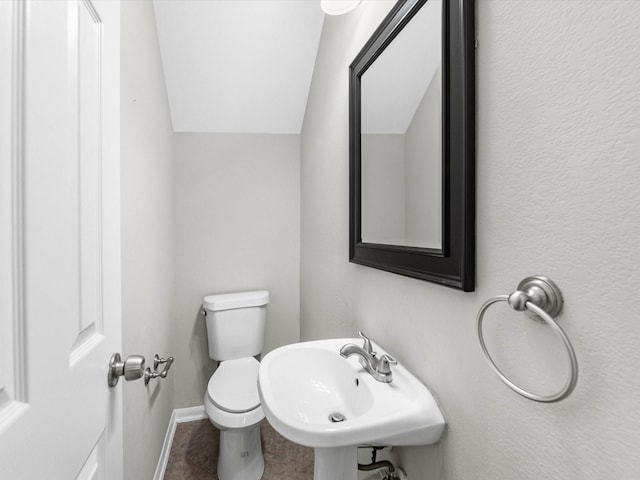 2234 Naomi St, Houston, TX 77054 - bathroom featuring lofted ceiling, a sink, toilet, baseboards, and tile patterned flooring