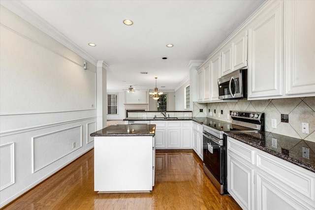 2263 Austin St, Houston, TX 77002 - kitchen with appliances with stainless steel finishes, dark wood-type flooring, a kitchen island, backsplash, and white cabinetry