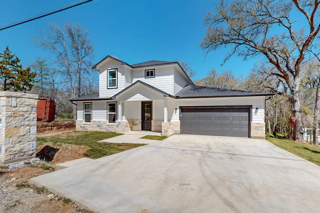 176 Kaelepulu Dr, Bastrop, TX 78602 - view of front of house with stone siding, an attached garage, driveway, and a front yard