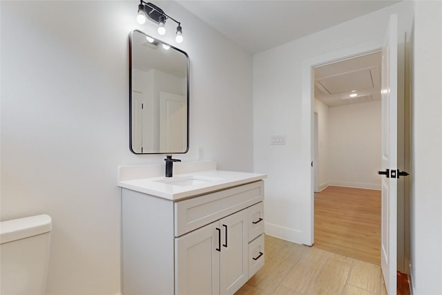 176 Kaelepulu Dr, Bastrop, TX 78602 - bathroom with vanity, toilet, baseboards, and wood finished floors
