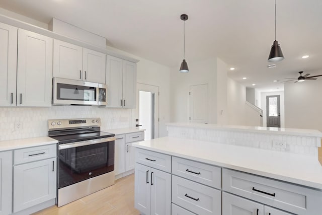 176 Kaelepulu Dr, Bastrop, TX 78602 - kitchen with stainless steel appliances, backsplash, light wood-style flooring, light countertops, and recessed lighting