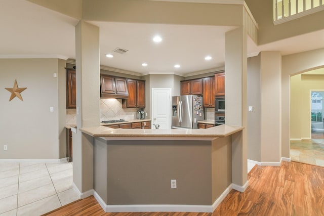 13814 Swan Hollow Ln, Houston, TX 77041 - kitchen featuring stainless steel appliances, backsplash, light countertops, a peninsula, and baseboards