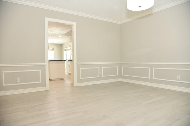 14103 Owens Rd, Houston, TX 77095 - spare room featuring light wood-type flooring, crown molding, wainscoting, baseboards, and a decorative wall