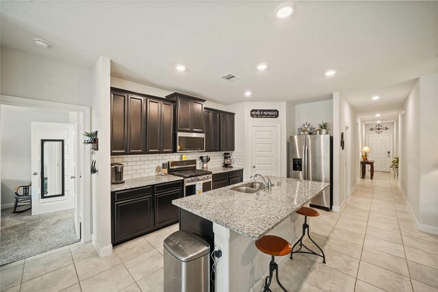 11607 Brookside Arbor Ln, Richmond, TX 77406 - kitchen with stainless steel appliances, a sink, a kitchen island with sink, light tile patterned floors, and recessed lighting