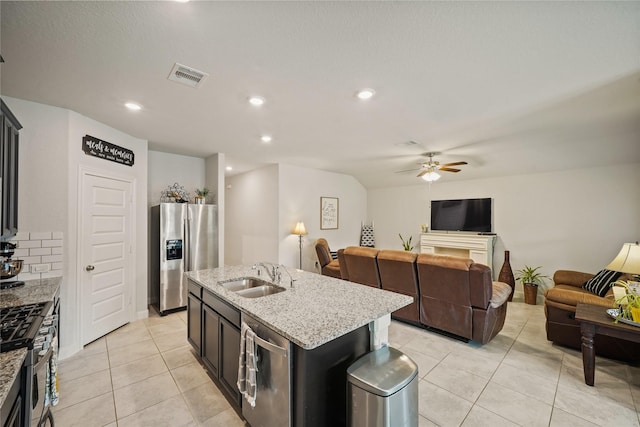 11607 Brookside Arbor Ln, Richmond, TX 77406 - kitchen with a sink, appliances with stainless steel finishes, light tile patterned flooring, ceiling fan, and an island with sink