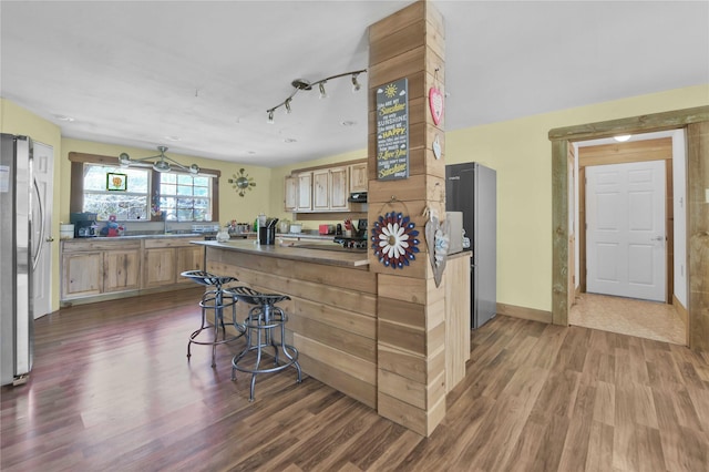 2000 E Beverly Dr, Shepherd, TX 77371 - kitchen with freestanding refrigerator, wood finished floors, exhaust hood, baseboards, and light brown cabinets