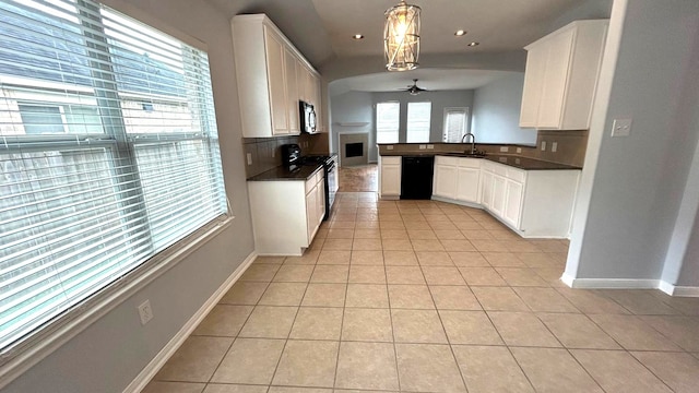 8106 Saragosa Blue Ln, Richmond, TX 77407 - kitchen with stove, black dishwasher, ceiling fan, light tile patterned floors, and dark countertops