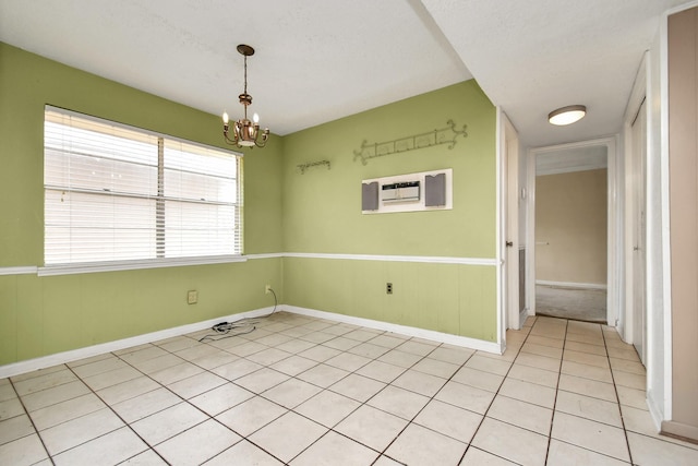 203 Kirkaldy Dr, Houston, TX 77015 - spare room featuring a chandelier, light tile patterned flooring, baseboards, a textured ceiling, and an AC wall unit