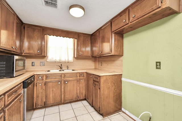 203 Kirkaldy Dr, Houston, TX 77015 - kitchen with a sink, stainless steel appliances, light countertops, light tile patterned flooring, and brown cabinetry