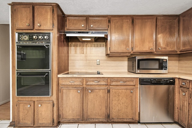 203 Kirkaldy Dr, Houston, TX 77015 - kitchen with black appliances, under cabinet range hood, light countertops, brown cabinetry, and a textured ceiling