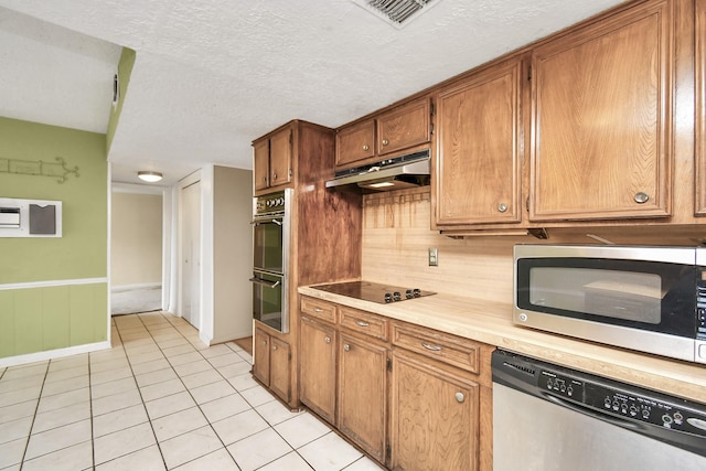 203 Kirkaldy Dr, Houston, TX 77015 - kitchen with black appliances, under cabinet range hood, light tile patterned floors, light countertops, and brown cabinetry