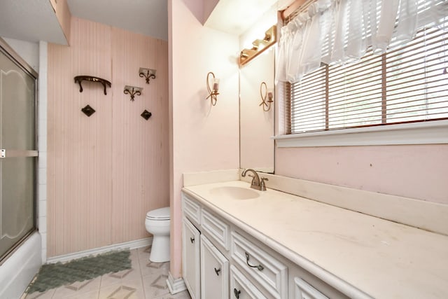 203 Kirkaldy Dr, Houston, TX 77015 - bathroom featuring vanity, toilet, tile patterned floors, shower / bath combination with glass door, and baseboards