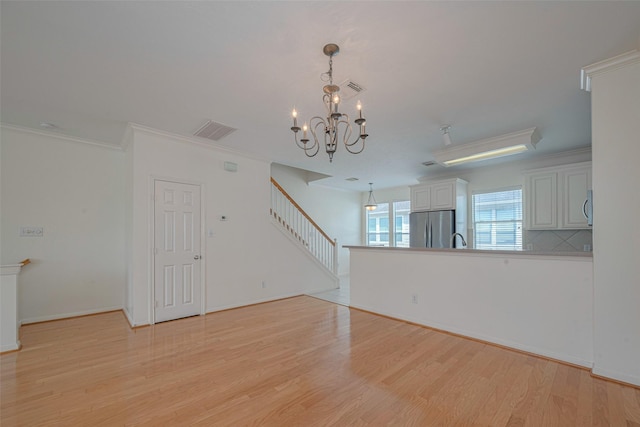 1715 Hadley St, Houston, TX 77003 - unfurnished room with light wood-type flooring, a chandelier, crown molding, stairs, and a sink