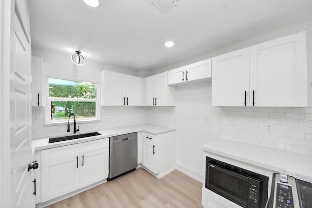11503 Duane St, Houston, TX 77047 - kitchen featuring stainless steel dishwasher, a sink, black microwave, white cabinetry, and light countertops