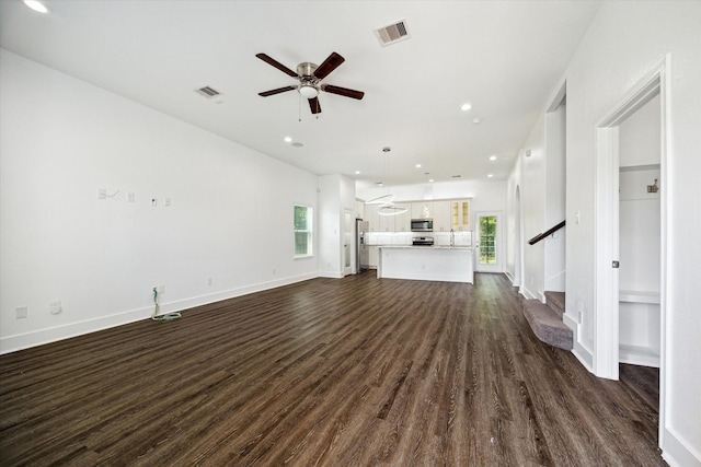 5041 Mallow St, Houston, TX 77033 - unfurnished living room featuring dark wood-style flooring, stairway, a ceiling fan, baseboards, and recessed lighting