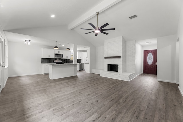 7414 Sunlight Ln, Houston, TX 77095 - unfurnished living room featuring ceiling fan, beamed ceiling, a fireplace, dark wood-type flooring, and baseboards