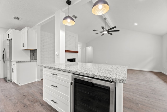7414 Sunlight Ln, Houston, TX 77095 - kitchen with wine cooler, freestanding refrigerator, a fireplace, light wood-type flooring, and a ceiling fan