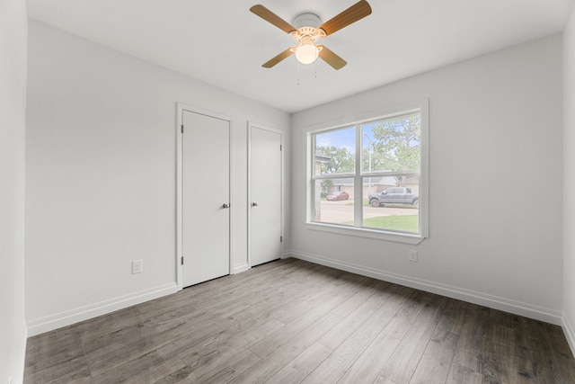 7414 Sunlight Ln, Houston, TX 77095 - unfurnished bedroom featuring wood finished floors, baseboards, and a ceiling fan