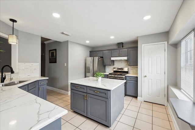 4138 Willow Bend Ln, Port Arthur, TX 77642 - kitchen featuring appliances with stainless steel finishes, a sink, tasteful backsplash, under cabinet range hood, and light stone counters