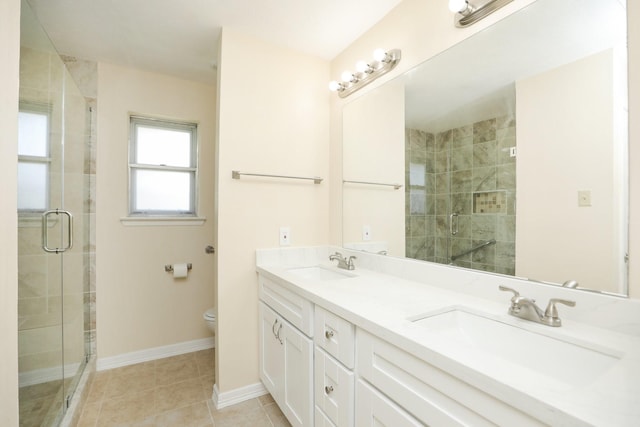 8606 Quail Vista Dr, Missouri City, TX 77489 - bathroom featuring double vanity, toilet, a shower stall, baseboards, and tile patterned floors