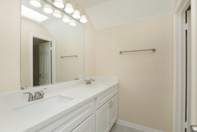 8606 Quail Vista Dr, Missouri City, TX 77489 - bathroom featuring double vanity, a skylight, baseboards, and lofted ceiling